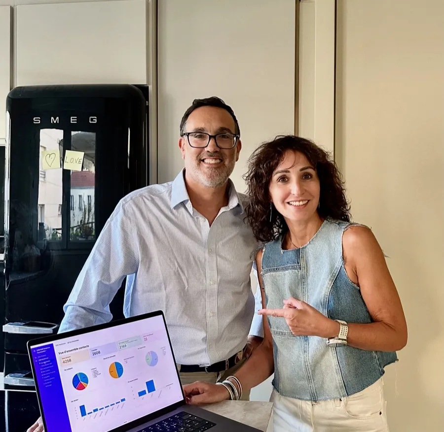 Julien Amar et Delphine Constantini dans une cuisine, derrière un ordinateur portable ouvert sur le tableau de bord de son CRM.